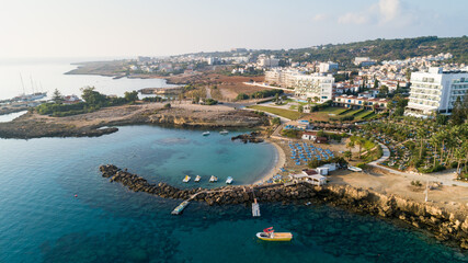 Fototapeta na wymiar Aerial bird's eye view of Green bay Protaras, Paralimni, Famagusta, Cyprus. Famous tourist attraction diving location rock beach with boats, sea restaurant, water sports on summer holidays, from above