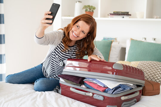 Mature Woman Taking Selfie With Suitcase