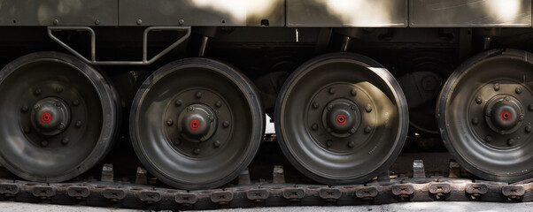 Naklejka na ściany i meble Tank truck and wheel closeup. Military background lateral part of heavy armored vehicles.