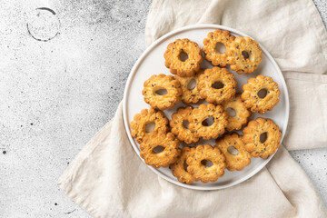 Shortbread in a large white ceramic plate on the light gray kitchen table. There are a lot of cookies in the plate. Homemade delicious pastries. Top view with space for text