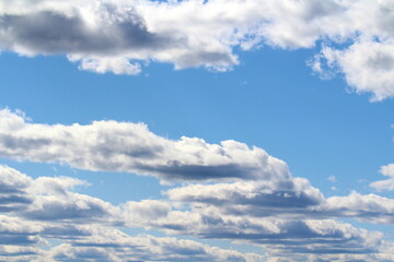 White fluffy clouds on a background of blue sky in summer. The concept of weather and climate