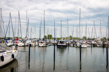 Fototapeta na wymiar Harbor full of pleasure yachts and sailing boats in the village of Makkum in the Netherlands, province of Friesland