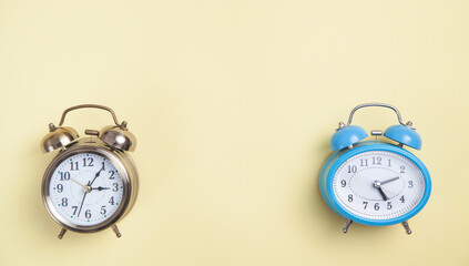 Alarm clocks on yellow background. Top view