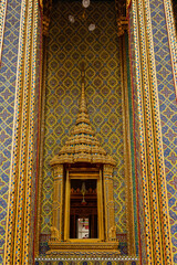 The wall of Wat Ratchabophit is decorated with Benjarong tiles. The others parts gilded with glass. above the pillars doors and windows was a castle-style arch, Bangkok, Thailand.