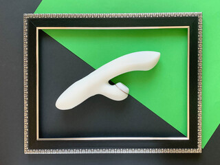 Sex toy. White vibrator on a green/black background. Useful for adult, sex shop