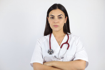 Young beautiful woman standing over white isolated background wearing her doctor uniform and smiling with arms crossed