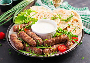 Pork kebab with pita bread with green onions.