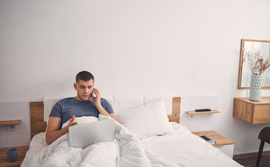 Anxious man working online from home in bedroom