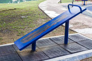 Outdoor fitness equipment for sit-up board and horizontal bar in a public park.