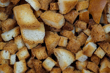 Selective focus on slices of fried white bread close-up. Tasty rosy croutons. Abstract food background.