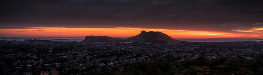 Dramatic panorama scene of sunrise sunset over the mountains - Arthur's Seat, Edinburgh