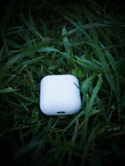 white wireless headphones on grass background