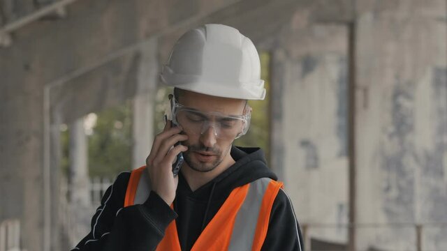 Construction engineer talking on the phone in a building under construction