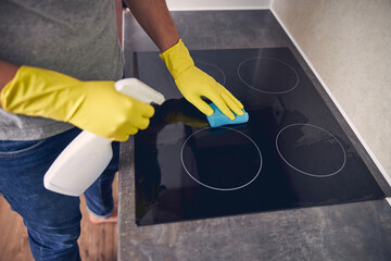 Cleaning kichen cooker with spray and yellow duster