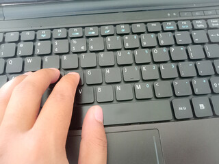 Typing hands on laptop keyboard