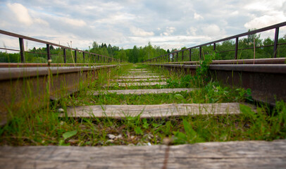 An old Abandoned railway, overgrown with green grass.