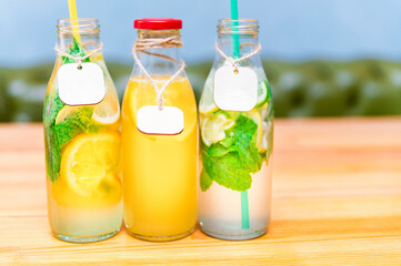 Set of bottles with lemonade or mojito cocktail with lemon and mint