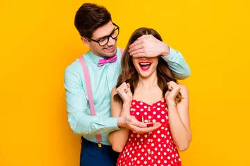 Fotobehang Two people crazy overjoyed girl man hide her eyes give jewelry ring ask marry him betrothal formalwear nerd style shirt suspenders red dotted dress isolated bright shine color background © deagreez