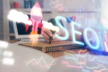 Multi exposure of woman's hands making notes with SEO icon. Concept of Search engine optimization