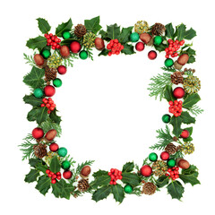 Square Christmas wreath decoration with holly, red & green bauble decorations & winter greenery on white background. Decorative abstract border for the festive season.