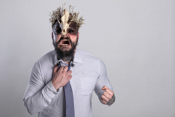 Anger and aggression. Strained relations or troubles in life. Screaming viking warrior with crown skull straightens the tie that strangles him