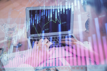 Multi exposure of market chart with man working on computer on background. Concept of financial analysis.