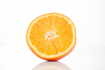 Sliced ​​orange on a white background with reflection at the bottom. Isolated photo of citrus.