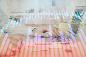 Multi exposure of stock market graph with man working on laptop on background. Concept of financial analysis.