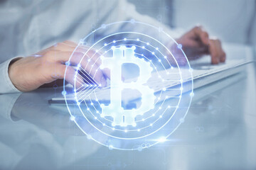 Crypto currency theme hologram with businessman working on computer on background. Concept of blockchain. Multi exposure.