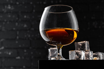 Whisky glass against dark black grunge wall