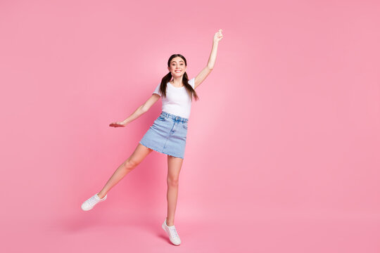 Full length photo of pretty lady jump high up catch imagine umbrella flying up with wind wear casual white t-shirt mini denim skirt shoes isolated pastel pink color background