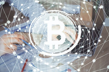 Crypto currency theme hologram with businessman working on computer on background. Concept of blockchain. Double exposure.