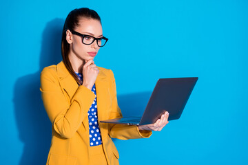 Portrait of her she nice attractive charming chic classy focused lady partner leader ceo boss chief holding in hands laptop browsing report isolated bright vivid shine vibrant blue color background