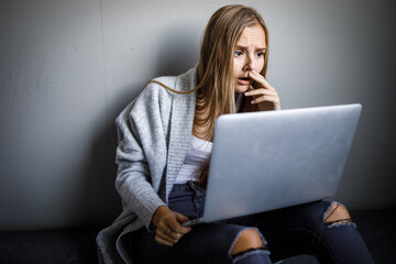 Pretty, young woman with her laptop studying for an exam/working