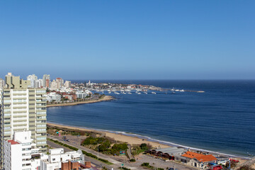 Balcony view of the coastline at a holiday resort in Punta Del Este, Uruguay: the quiet beach and boats in the harbour at the background on a clear sunny day of winter.