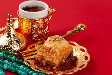 Turkish baklava and coffee in oriental dishware on red background