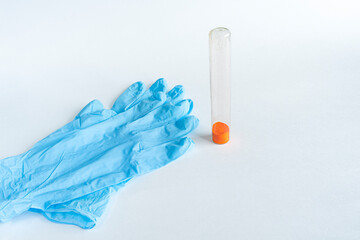 loose orange substance in a flask, medicine, next to blue gloves