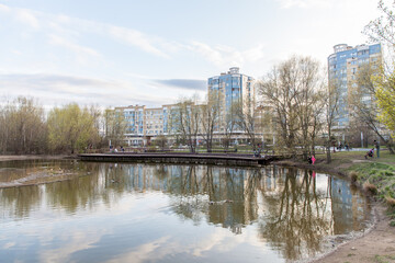 Naklejka premium Residential buildings near the pond during spring