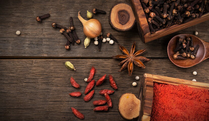 Various spices cinnamon, turmeric, pepper and anise, onions, coriander in wooden boxes on a wooden table © KONSTANTIN