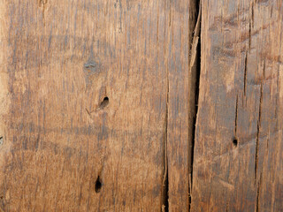 Background picture of middle brown old oak wood with cracks and old drill holes.