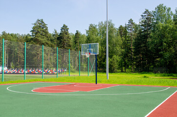 Empty sreet basketball court in the park on the sunny summer day.