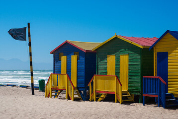 Colorful beach houses and blue sky  in Muizenberg Beach in South Africa.  Multi-colored beach huts in Western Cape. Shark bay.