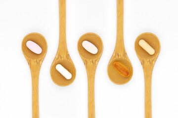 Vitamin supplements on wooden teaspoons