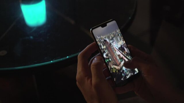 Person watching aerial photo of Bangkok Thailand on a smartphone