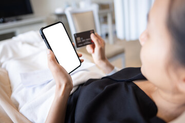 Fototapeta na wymiar patient female using smartphone and credit card making payment while Lie on the patient's bed at the hospital.