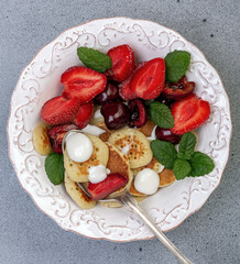 Tiny pancakes with berries. Trendy food.