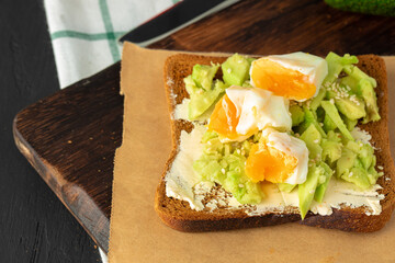 Sandwich with fried egg and avocado pieces