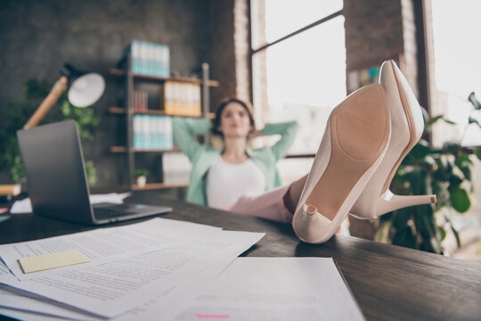 Blurry focus photo of business lady hold hands behind head look up dreamy imagination flight minded resting remote distance work legs wear high-heels lying on table sit chair office indoors