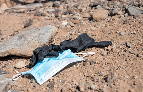 Medical mask and plastic gloves used against coronavirus infection and thrown on the street. Civic sense and respect for the environment totally missing