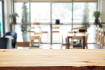 Empty wooden desk space platform over blurred restaurant or coffee shop background for product display montage.